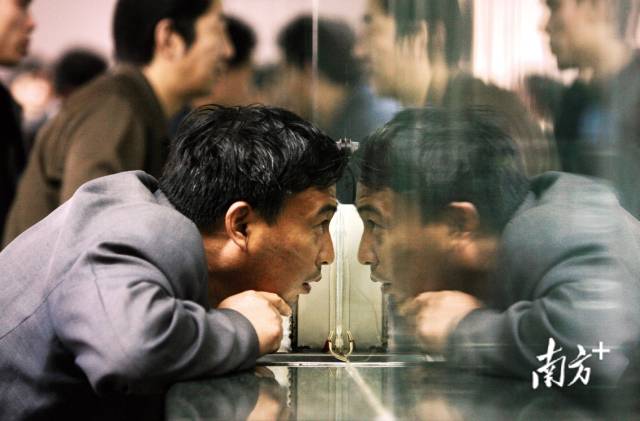 2006年1月18日，广州火车站售票厅，一名男子趴在售票窗口询问是否还能买到回家的车票。