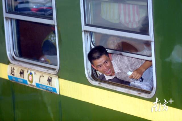 2004年1月，广州火车站，一位成功登上车的旅客从车窗探出身体兴奋地对着还在车下的同伴喊叫。