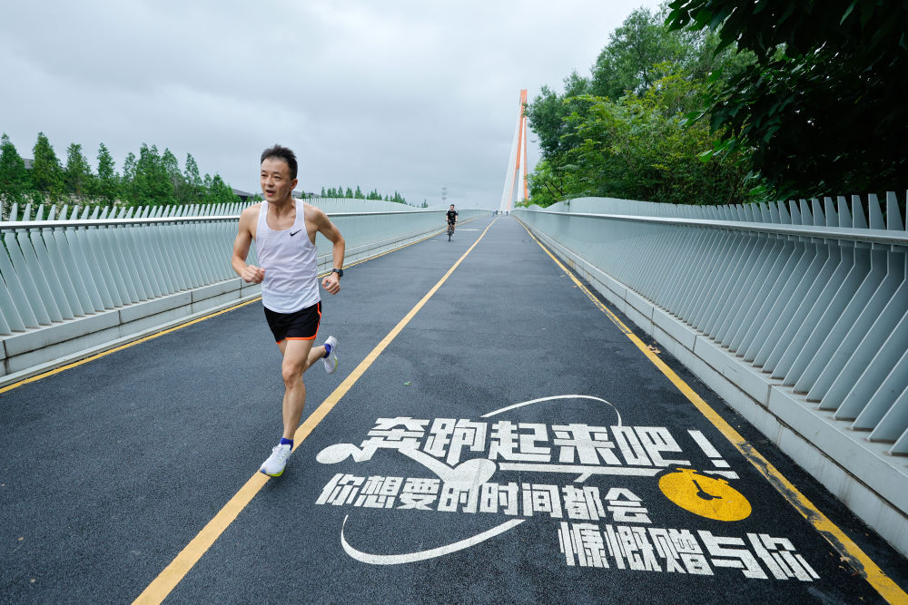2024年7月14日，市民在四川成都锦城湖公园进行跑步训练。