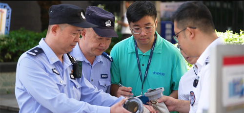 图为民警与网格员在小区进行消防安全检查。