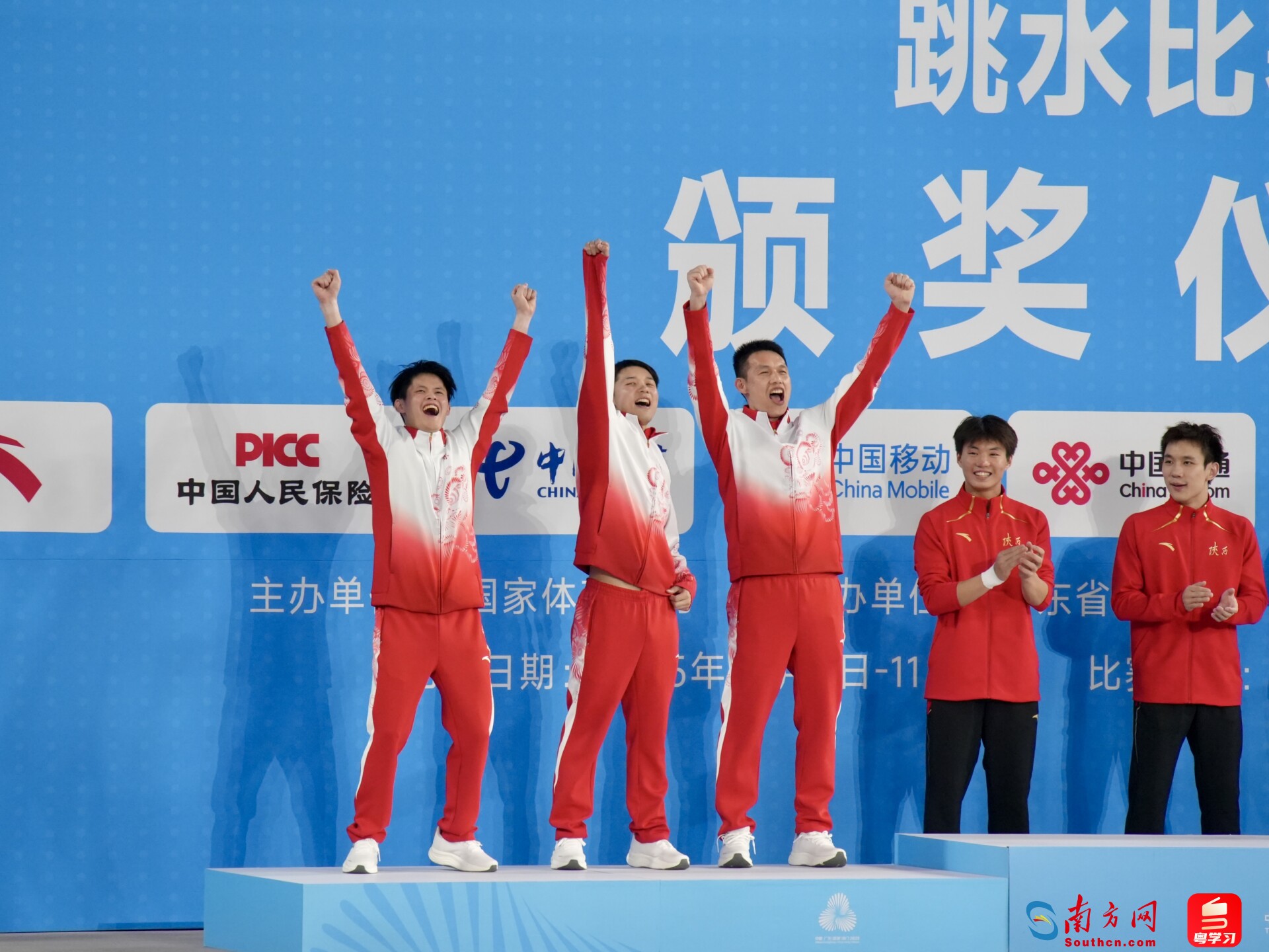 陈艾森(中)与朱子锋(左)及其教练登上领奖台。