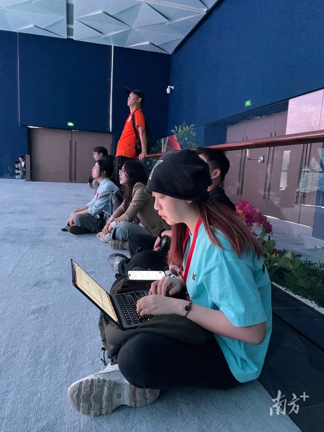 记者坐在地上写稿