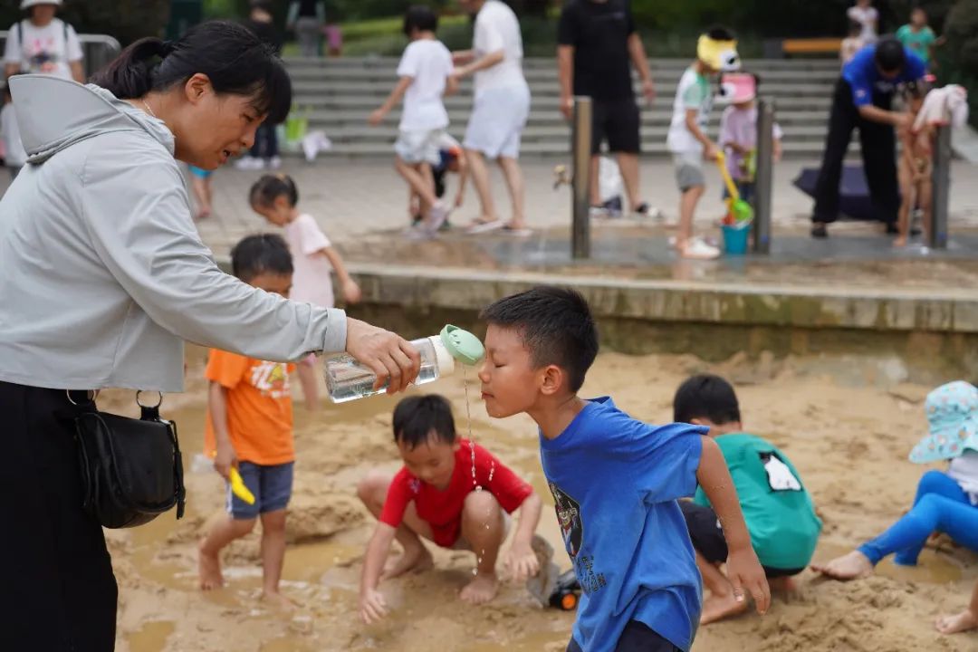 广州市儿童公园，一名家长正给孩子喝水。（南方周末记者 翁洹/图）