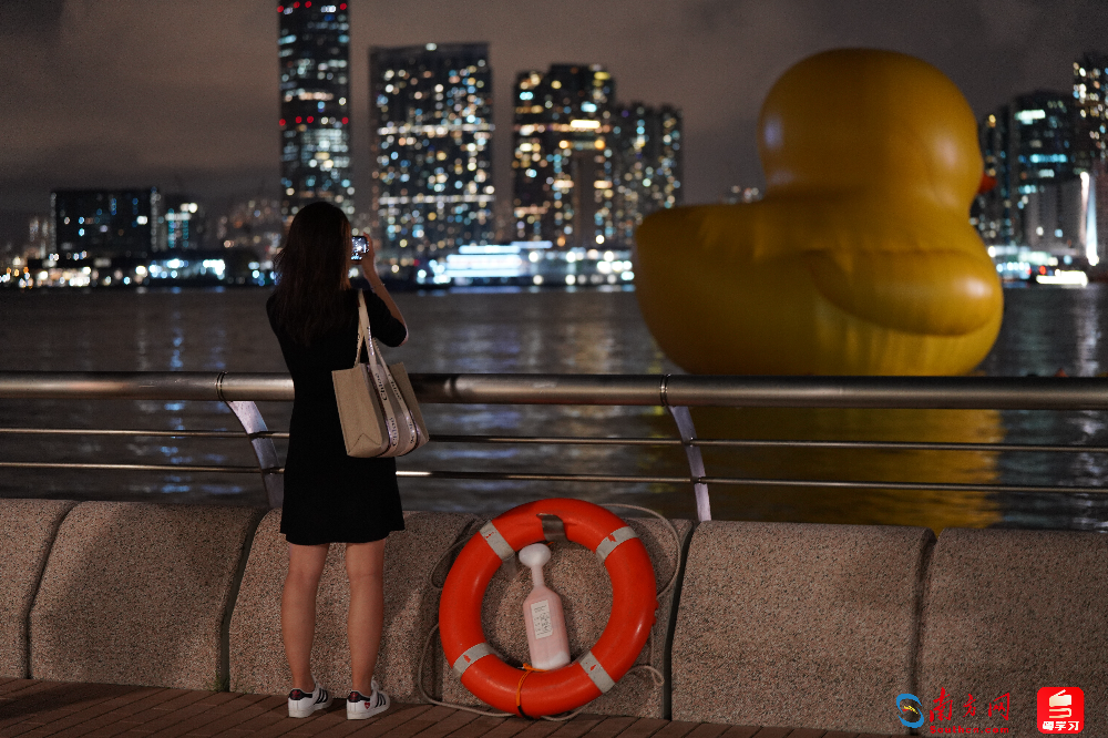 游客驻足观看拍摄“大黄鸭”