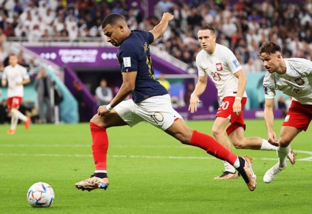 2022卡塔尔世界杯足球赛八分之一决赛中，法国队以3比1战胜波兰队。图为法国队球员姆巴佩（左）射门。新华社发