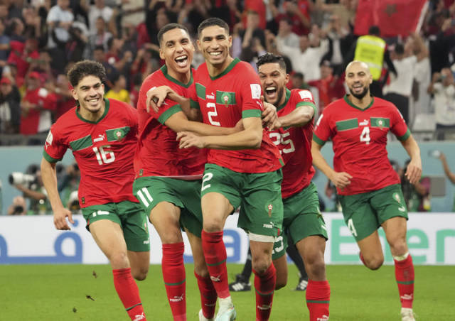 摩洛哥队球员阿什拉夫（左三）在点球大战中射门得分后与队友庆祝胜利。新华社发