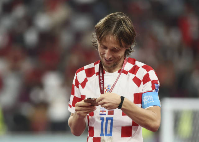 12月17日，克罗地亚队球员莫德里奇在季军颁奖仪式后注视自己的奖牌。新华社记者 兰红光 摄