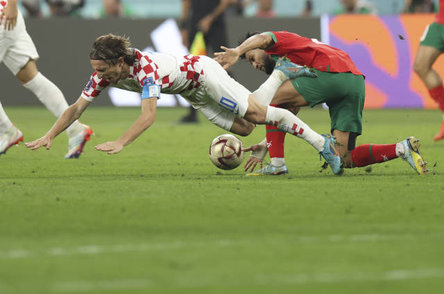 12月17日，克罗地亚队球员莫德里奇（左）在比赛中突破受阻。    当日，在卡塔尔多哈哈里发国际体育场进行的2022卡塔尔世界杯足球赛三、四名决赛中，克罗地亚队以2比1战胜摩洛哥队，获得季军。