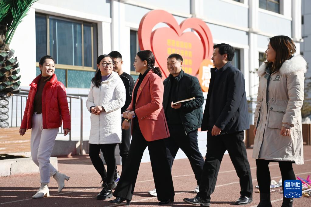 在甘肃临夏回族自治州积石山县吹麻滩小学，董彩云（右四）和学校老师交流，收集建议（2022年2月23日摄）。新华社记者 范培珅 摄