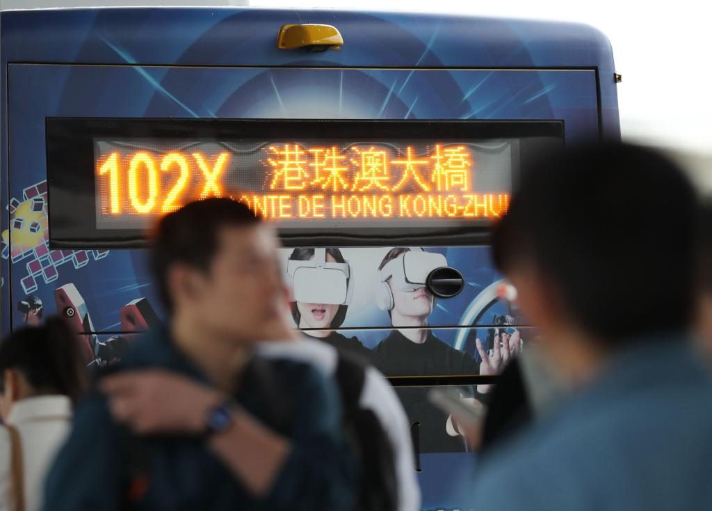 市民和旅客在横琴口岸澳门口岸区排队，准备登上前往港珠澳大桥方向的公交车。新华社记者 王益亮 摄