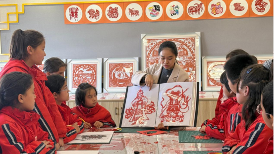 广州援疆教师陆婉静向学生展示《哪吒之魔童闹海》人物剪纸。