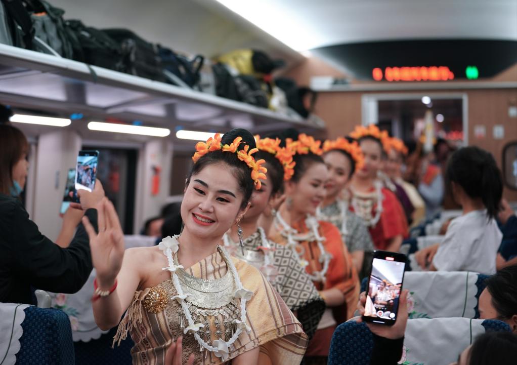 2023年4月13日，老挝工作人员在中老铁路上开行的D887次国际旅客列车上表演。新华社记者邢广利摄