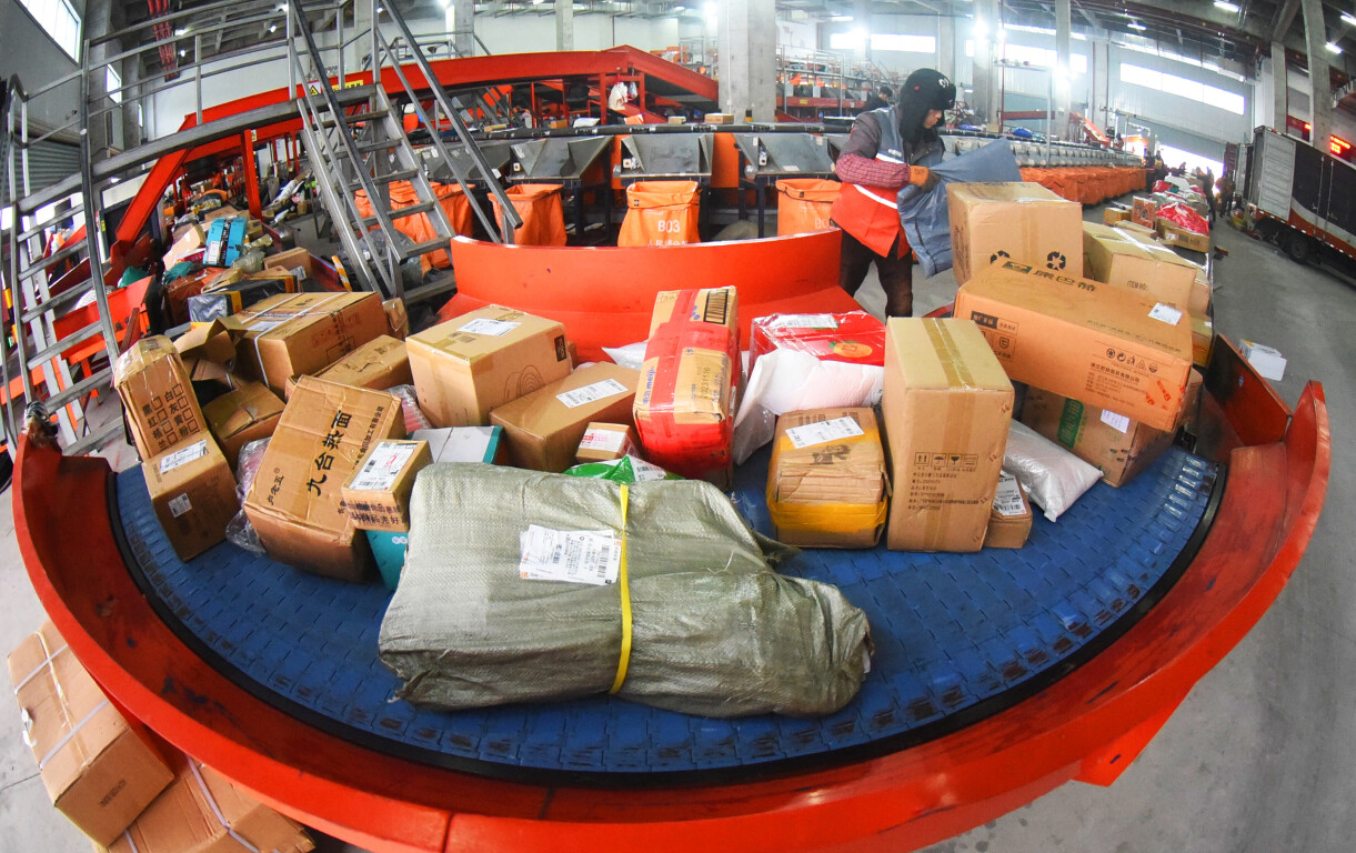 2024年2月5日，江苏省连云港市公用配送中心一家快递公司工作人员正在加紧分拣、发送快递包裹。