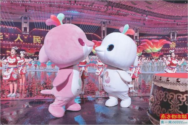 吉祥物“乐融融”和“喜洋洋”在十五运会的水舞台边上表演“亲亲”。