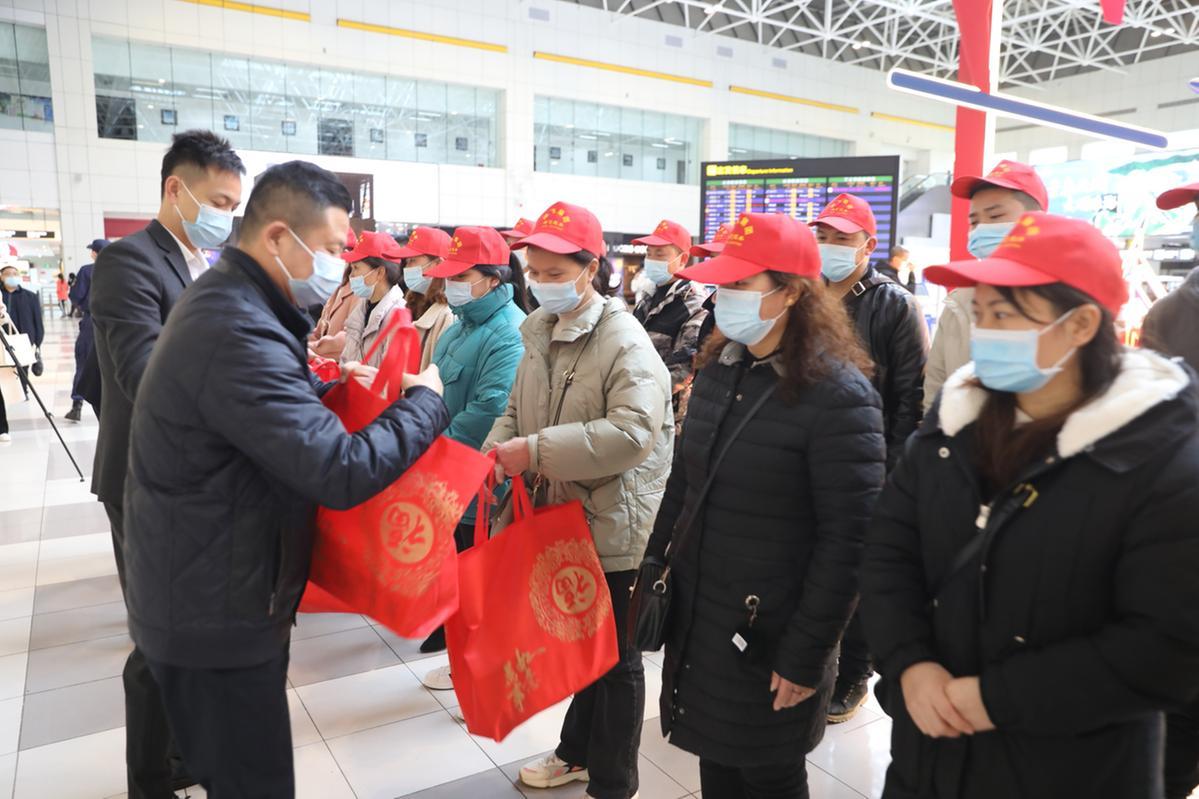 遵义务工人员乘坐专机抵达珠海机场，珠海人社部门工作人员现场接机并为他们发放慰问礼包。（摄影：吴长赋）