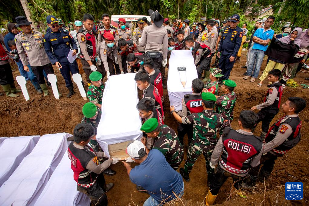 12月11日,在印度尼西亚西苏门答腊省,警察为遇难者举行集体葬礼。新华社发(安德里·马迪安赛亚摄)