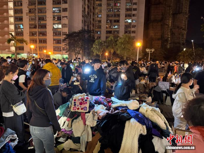 11月27日晚,志愿者在香港大埔宏福苑附近的社区广场分拣、派发捐赠衣物。 罗英杰 摄