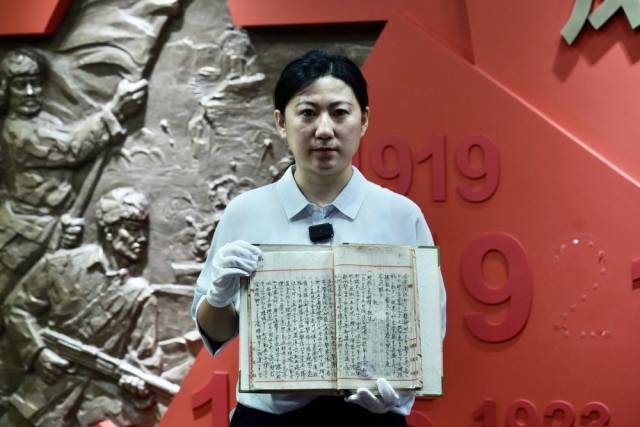 黑龙江省档案馆工作人员赵倩展示这份档案。新华社记者 何山 摄
