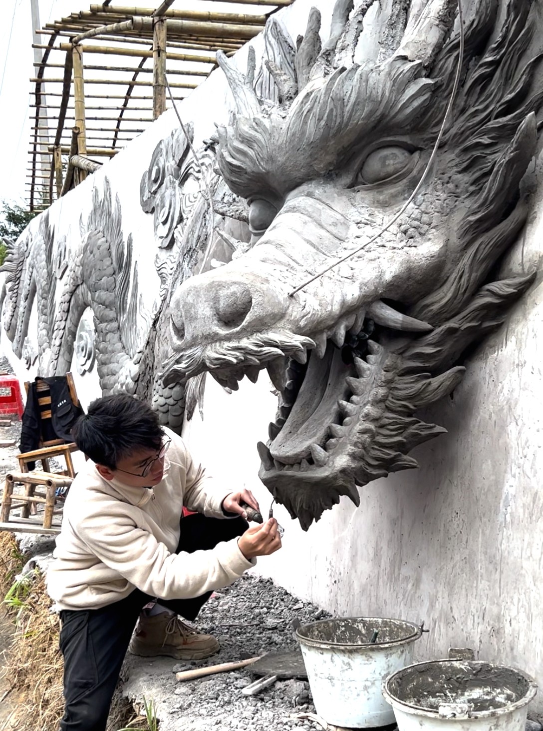 福建龙岩市古龙村，梁铭杰在创作30米长《神龙》浮雕。（受访者供图）