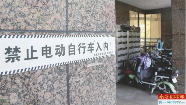 东莞消防部门在居民楼张贴的飞线警示语，但还是非法有电动自行车违规停放。