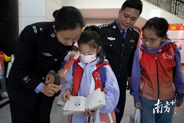 一名小记者向警员展示她所画的警察肖像。