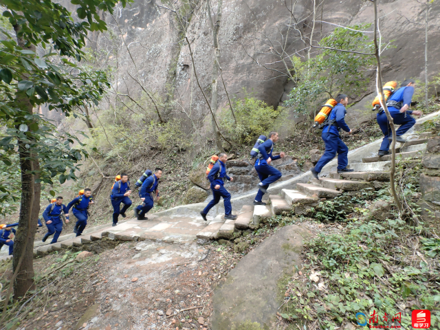 消防员们背着空气呼吸器冲上山顶。