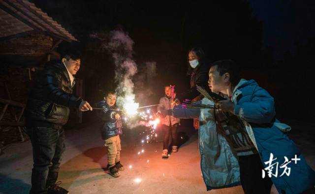 回家日恰逢小年夜，黄炳东一家五口在院子里点起烟火庆祝。 