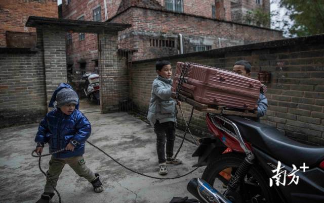 到家后，黄炳东的三个儿子合力帮助爸爸卸下行李。
