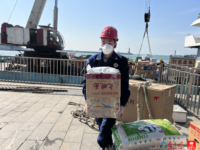 桂山岛消防救援站队员在码头搬运订好的物资。