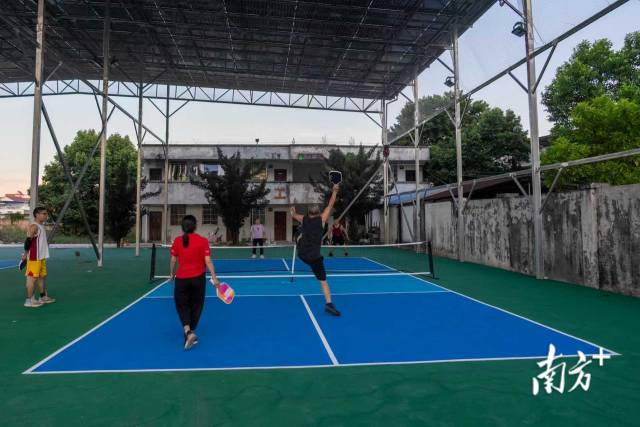 刚收工的村民们握拍上阵，清脆的击球声伴着欢笑声，成为小镇夜晚活力涌动的注脚。