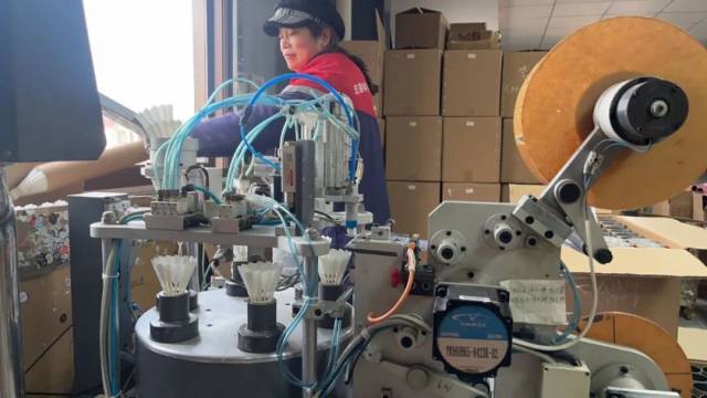 ▲2026年1月12日，叶光兴的工厂内，工人给羽毛球贴上球心标 图/受访者提供