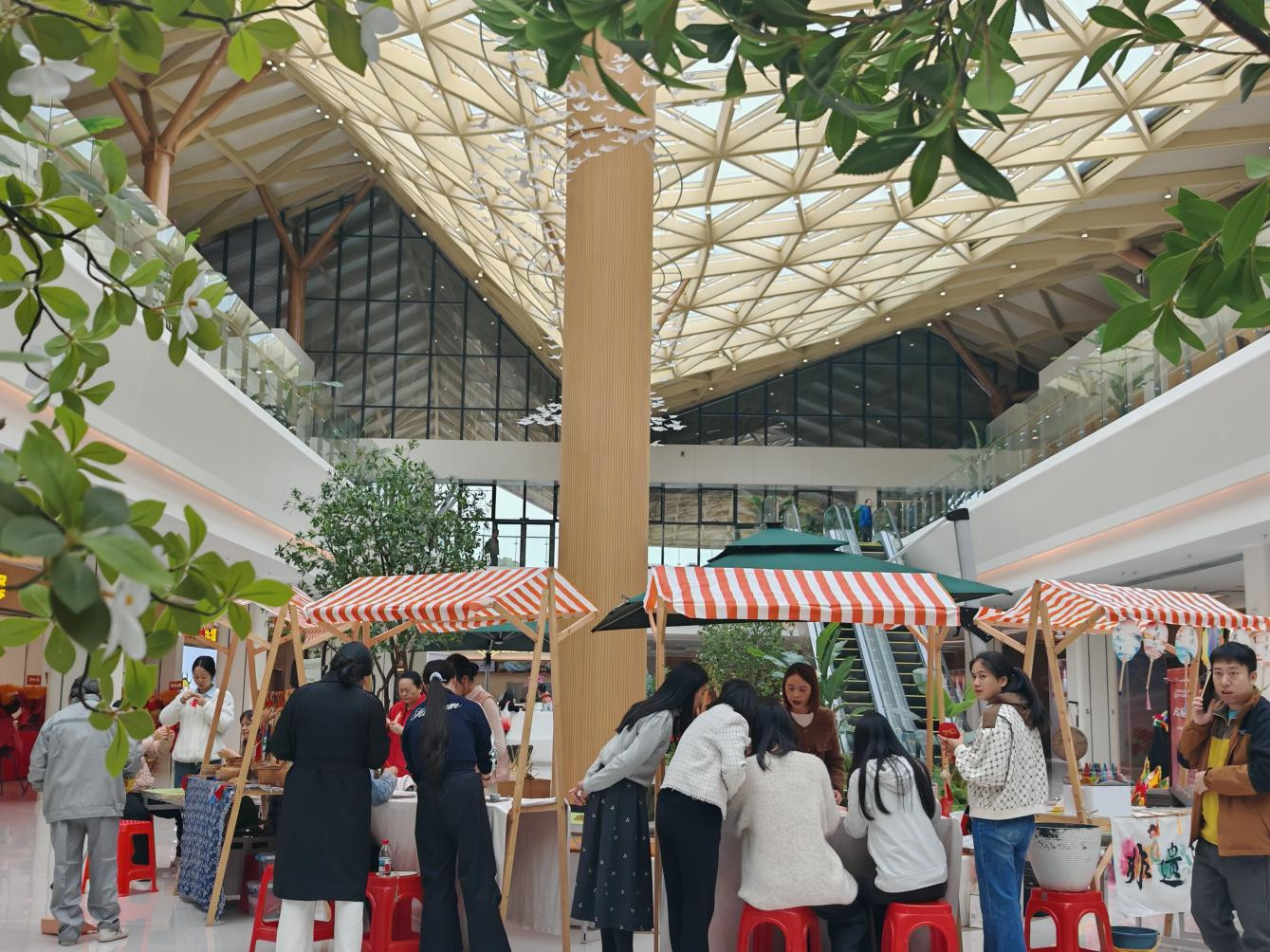 旅客在非遗体验区前体验拓印、竹编等