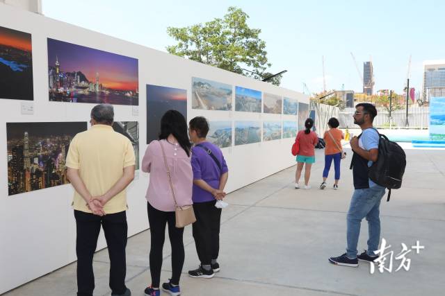 10月14日，在香港西九龙文化区文化广场，当地市民和游客在参观“水·融”——粤港澳大湾区人文摄影展。