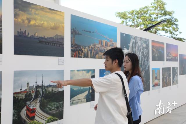 10月14日，在香港西九龙文化区文化广场，当地市民和游客在参观“水·融”——粤港澳大湾区人文摄影展。