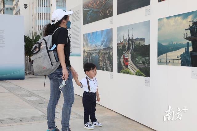 10月14日，在香港西九龙文化区文化广场，当地市民和游客在参观“水·融”——粤港澳大湾区人文摄影展。